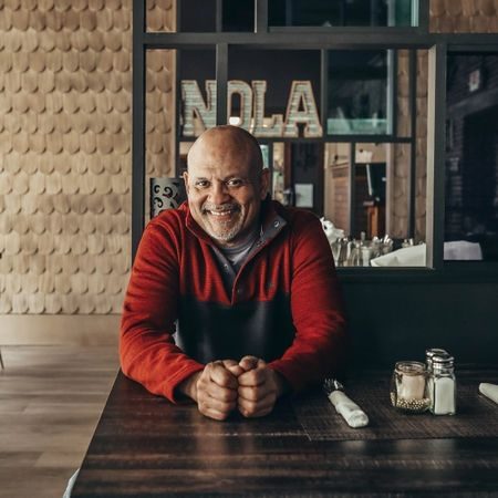 Chef Mike Adams, owner and executive chef of Blue Orleans, seated at a table