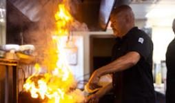 Chef Mike flambéing a pan in the kitchen