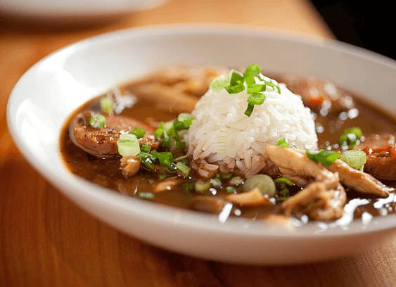 Crawfish étouffée with a scoop of white rice and green onions
